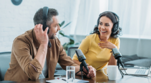 Man and woman filming a podcast with Push Button Productions in a studio.