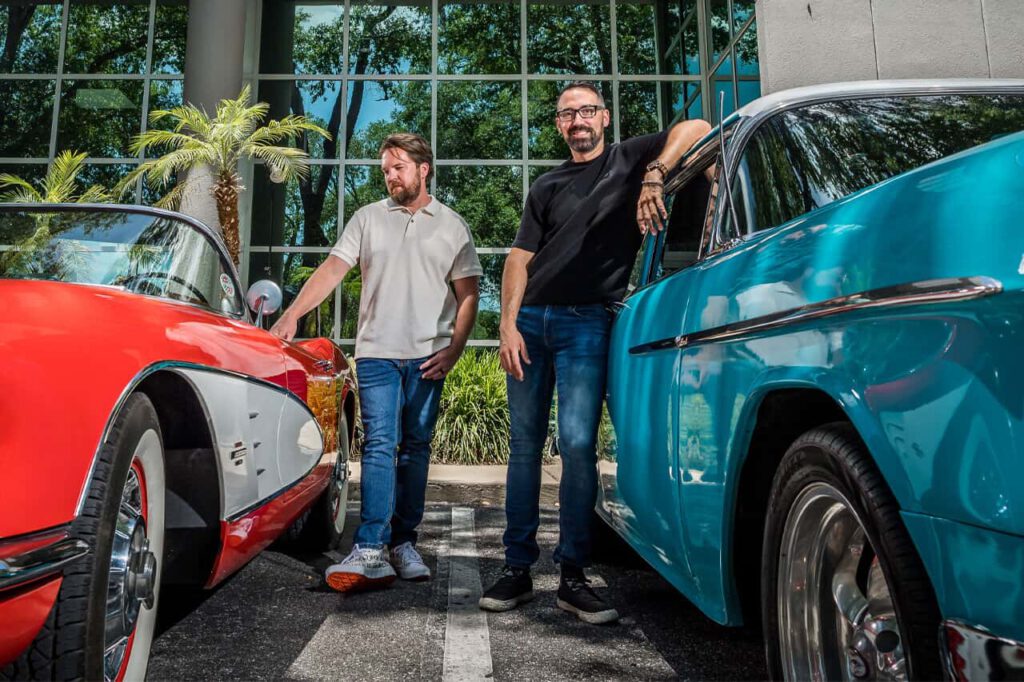 Photo of Yeosh and Jon with vintage cars in front of Push Button Productions