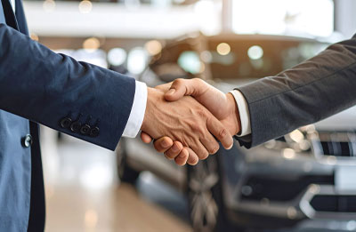 Photo of two men shaking hands at car dealership