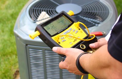 Photo of HVAC tech running diagnostics on outdoor HVAC