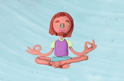 Photo of clay figure sitting with legs criss crossed