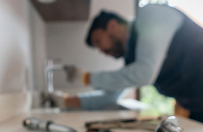 Photo of plumber working on sink
